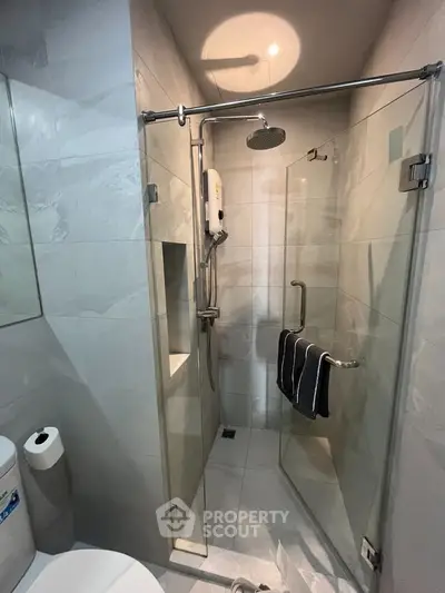 Modern bathroom with glass shower enclosure and sleek fixtures