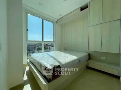 Bright and modern bedroom with large window and built-in storage, offering a stunning city view.