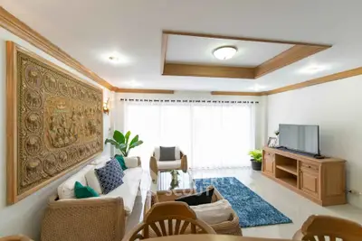 Spacious living room with elegant decor and natural light, featuring a large wall art and modern furniture.
