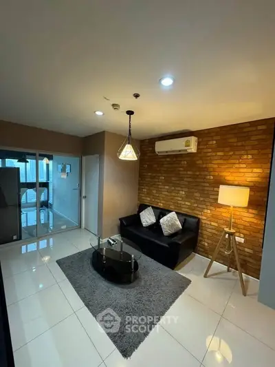 Modern living room with brick accent wall and sleek furnishings.