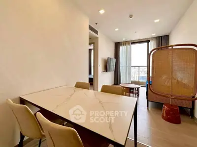 Modern living room with elegant dining area and city view balcony.