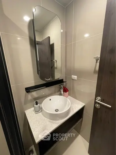 Modern bathroom with sleek vanity and stylish mirror in contemporary apartment.