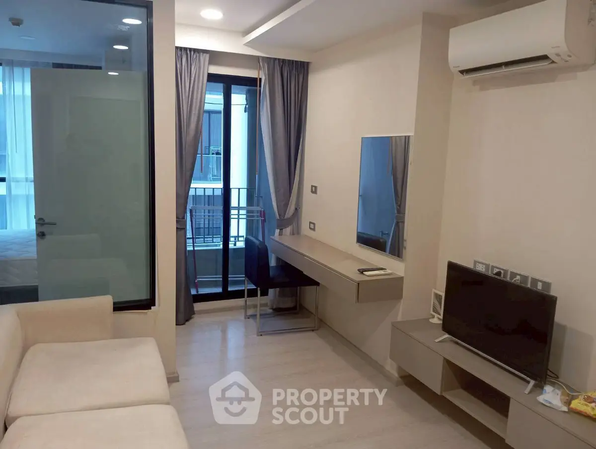 Modern living room with balcony, air conditioning, and sleek furniture in a stylish apartment.