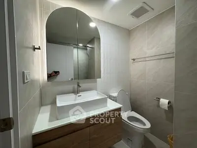 Modern bathroom with sleek vanity and large mirror in contemporary home.