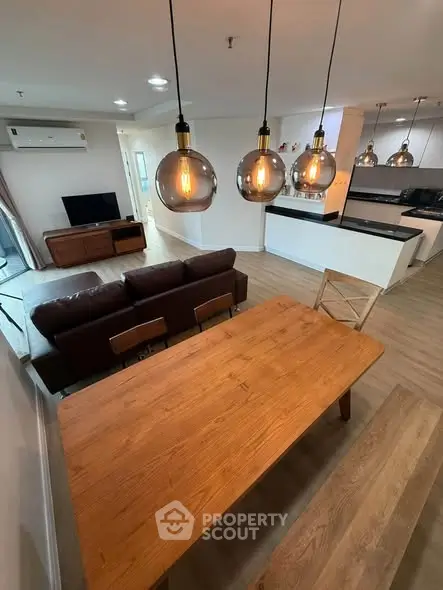 Spacious open-plan living room with modern kitchen and stylish lighting