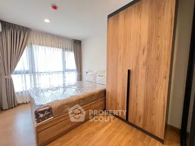 Modern bedroom with wooden flooring and large wardrobe in a bright apartment