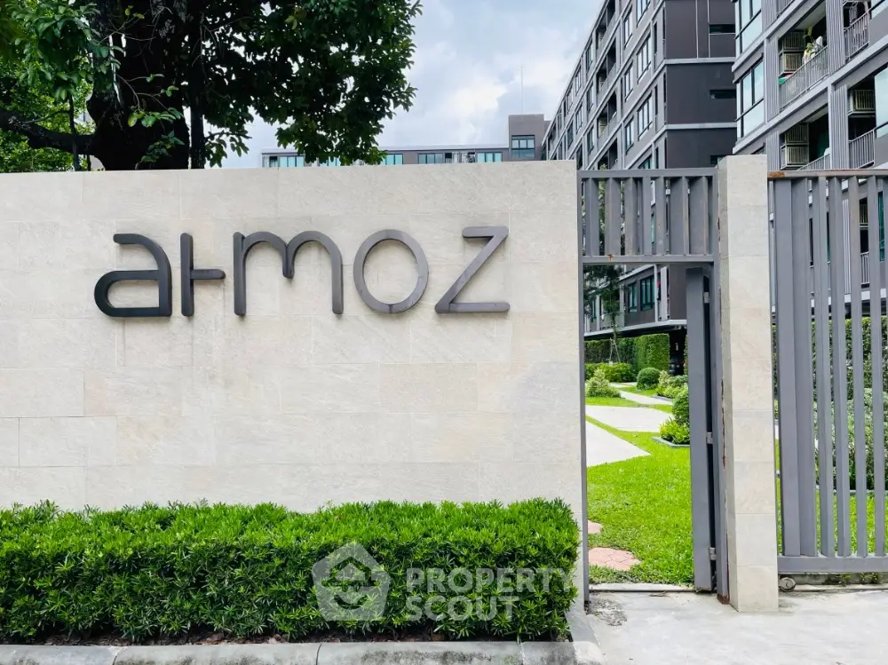 Modern apartment building entrance with lush greenery and sleek design.