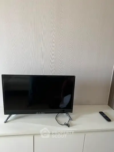 Modern minimalist living room with sleek TV setup on white cabinet