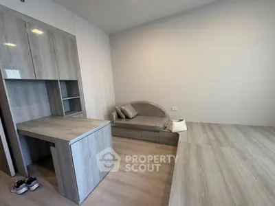 Modern minimalist living room with sleek wooden furniture and cozy seating area.