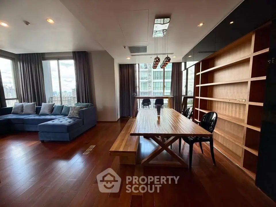 Spacious living room with elegant wooden flooring and large windows offering natural light.