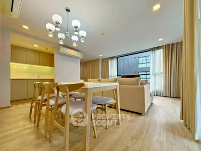 Modern open-plan living and dining area with elegant lighting and natural light.