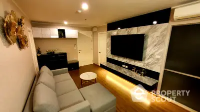 Modern living room with stylish decor and large wall-mounted TV