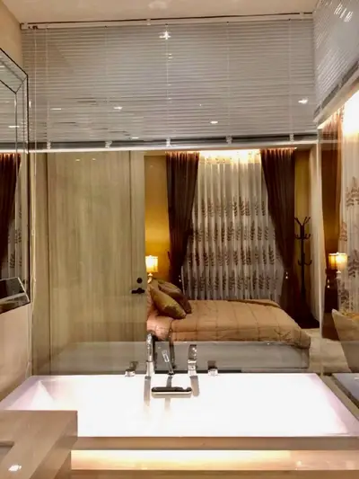 Luxurious bedroom with elegant decor and ambient lighting, featuring a stylish bathroom view.