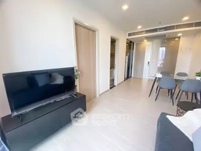 Modern living room with sleek furniture and dining area in open layout apartment.