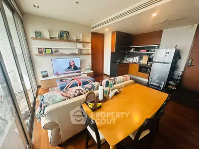 Modern living room with open kitchen, stylish decor, and natural light