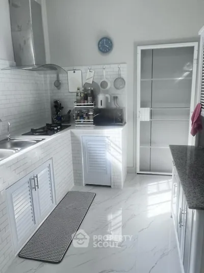 Modern kitchen with sleek white cabinetry and marble flooring