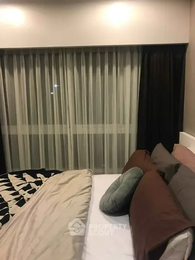 Cozy bedroom with modern decor and large window with curtains