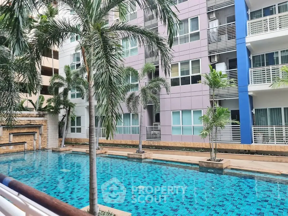 Modern apartment building with a stunning pool and palm trees, perfect for luxury living.