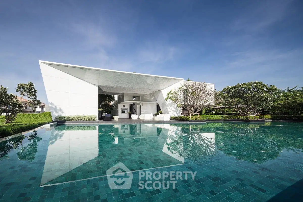 Luxurious modern building with stunning pool and lush greenery, perfect for relaxation and leisure.