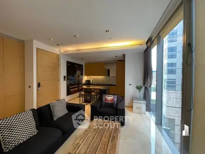 Modern living room with open kitchen and city view, featuring sleek design and natural light.