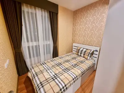 Cozy bedroom with elegant wallpaper and stylish bedding in modern apartment.