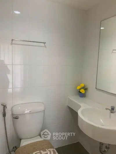 Modern bathroom with sleek white fixtures and a touch of decor elegance.