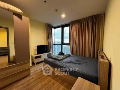 Modern bedroom with large window and city view, featuring stylish furniture and cozy ambiance.