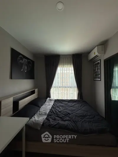 Cozy bedroom with modern decor, featuring a large window and stylish elephant artwork, perfect for relaxation.