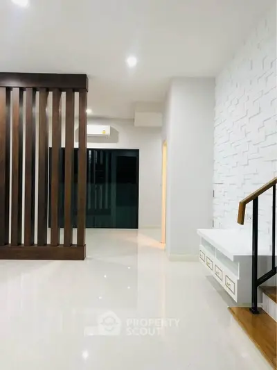 Modern interior with sleek wooden partition and textured white wall in a stylish living space.