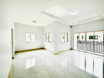 Spacious and bright living room with large windows and balcony access
