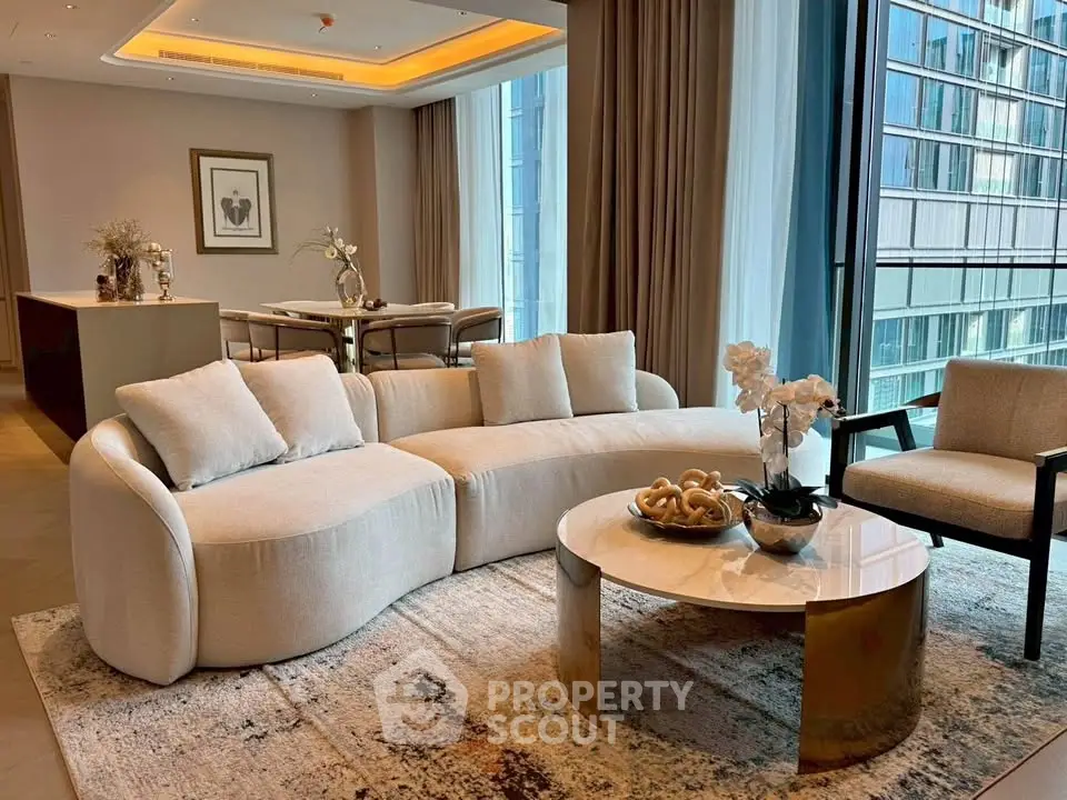 Luxurious modern living room with elegant furniture and large windows offering stunning city views.