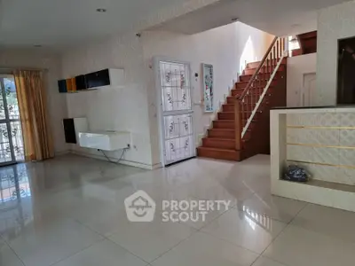 Spacious modern living room with elegant staircase and natural light