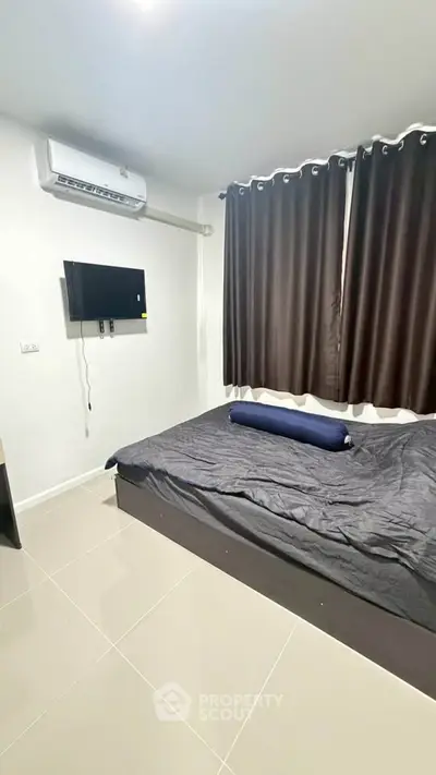Modern bedroom with air conditioning and wall-mounted TV, featuring sleek curtains and a comfortable bed.
