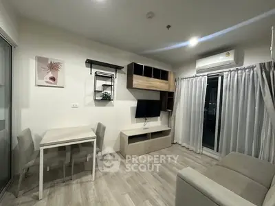 Modern living room with sleek furniture and air conditioning, featuring a cozy dining area and stylish decor.