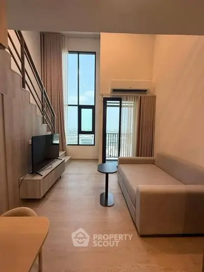 Modern living room with high ceilings, large windows, and stylish furniture in a contemporary apartment.