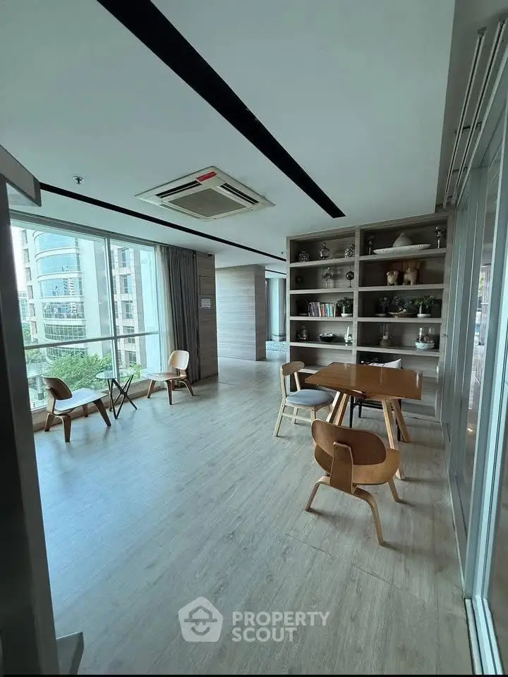 Modern living room with stylish furniture and large windows offering city views.