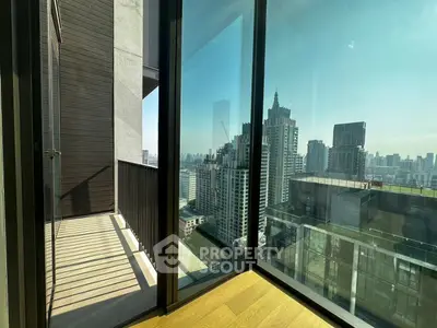 Stunning city view from modern high-rise balcony with floor-to-ceiling windows.