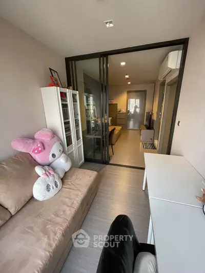 Cozy living room with plush toys and modern decor, featuring sliding glass doors and ample natural light.