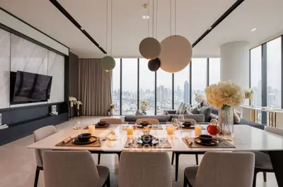 Luxurious modern living room with panoramic city views and elegant dining setup.