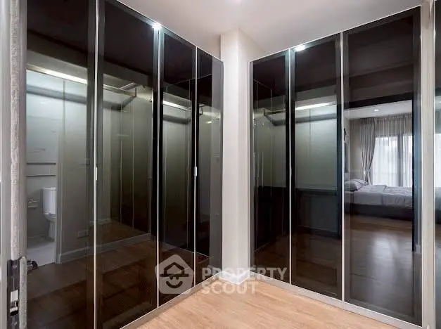 Spacious bedroom with mirrored closet doors and wooden flooring