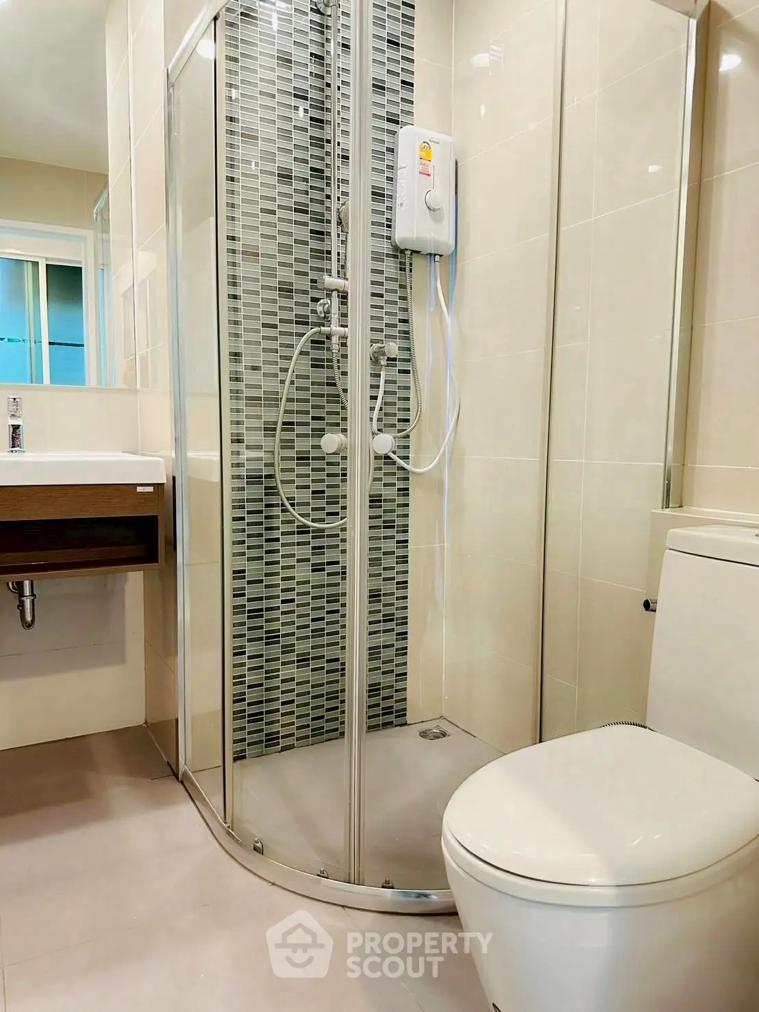 Modern bathroom with glass shower and sleek fixtures in contemporary apartment.