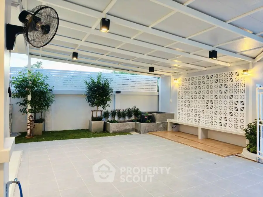 Spacious covered patio with modern design and garden view, perfect for outdoor relaxation.