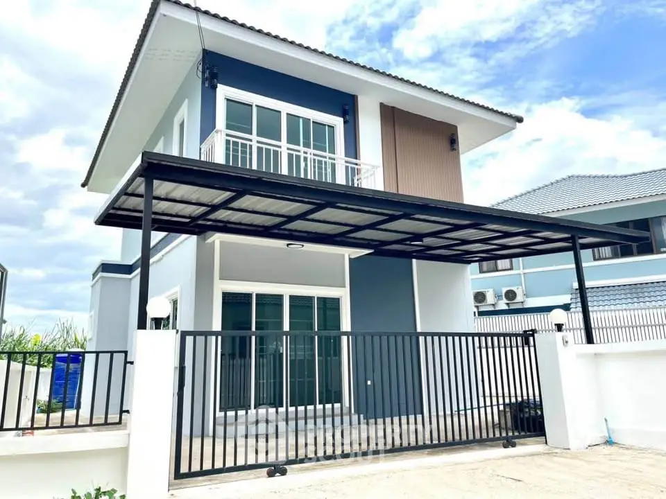 Modern two-story house with sleek design and gated entrance, featuring large windows and a covered carport.