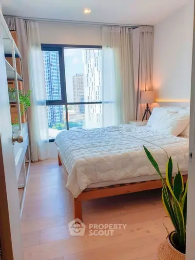 Bright and cozy bedroom with city view, featuring modern decor and natural light.