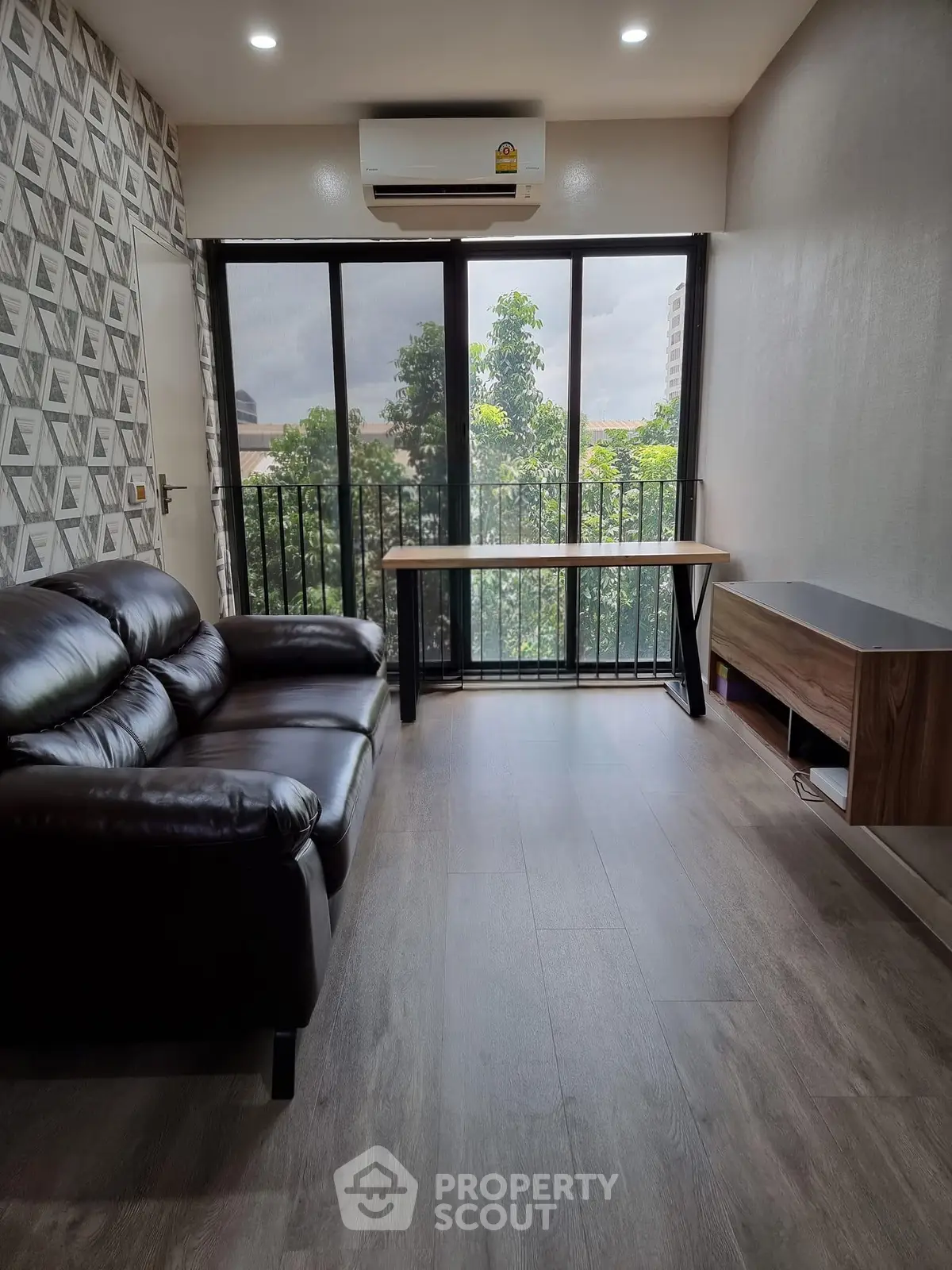 Modern living room with sleek design, featuring a leather sofa and large windows with a view.