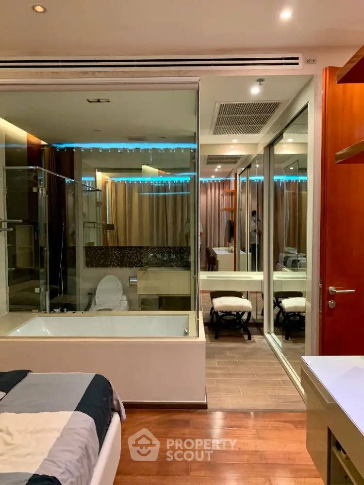 Luxurious bedroom with glass-walled bathroom and modern decor