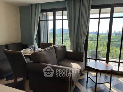Stylish living room with large windows and balcony offering a stunning view of the city skyline.