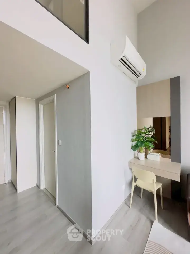 Modern apartment interior with sleek design and air conditioning, featuring a cozy study nook.