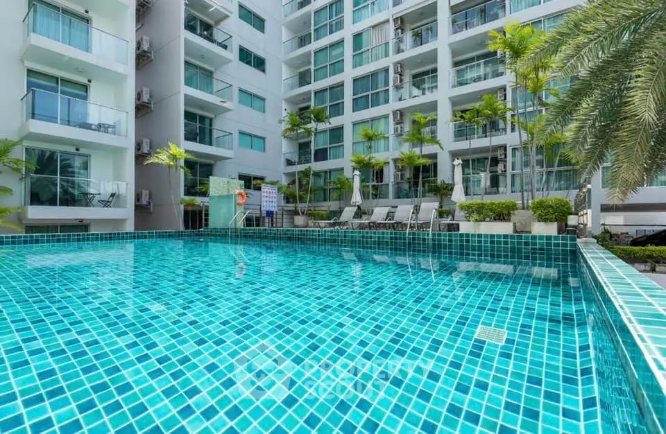 Luxurious apartment complex with sparkling pool and lush greenery