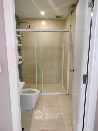 Modern bathroom with glass shower enclosure and sleek design.